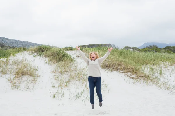Mujer mayor saltando en la playa —  Fotos de Stock