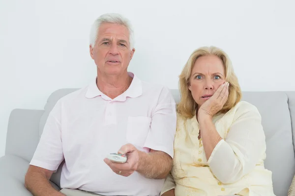 Geschokt senior koppel televisie kijken — Stockfoto