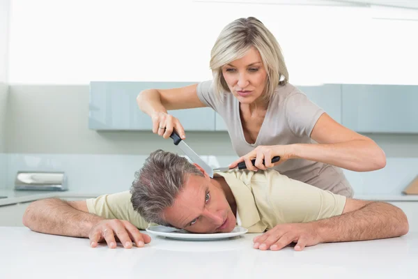 Femme en colère tenant couteau au cou de l'homme dans la cuisine — Photo