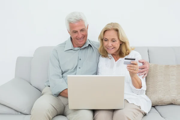 Senior couple doing online shopping on sofa — Stock Photo, Image