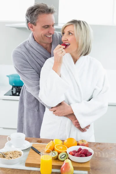 Mann umarmt Frau von hinten in Küche — Stockfoto