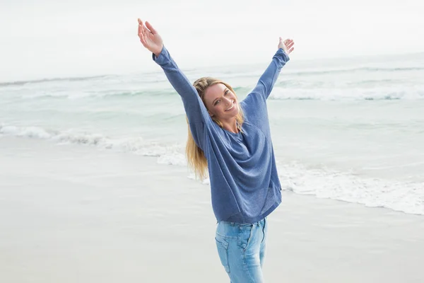 Счастливая женщина стоит с поднятыми на пляже руками — стоковое фото