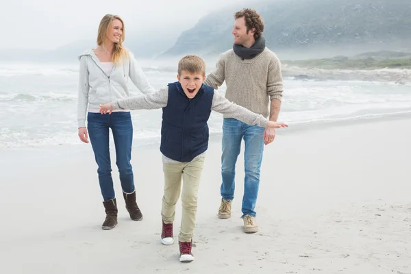 Счастливая семья из трех человек на пляже — стоковое фото