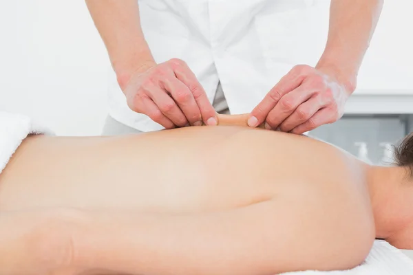 Mid section of a physiotherapist massaging woman\'s back