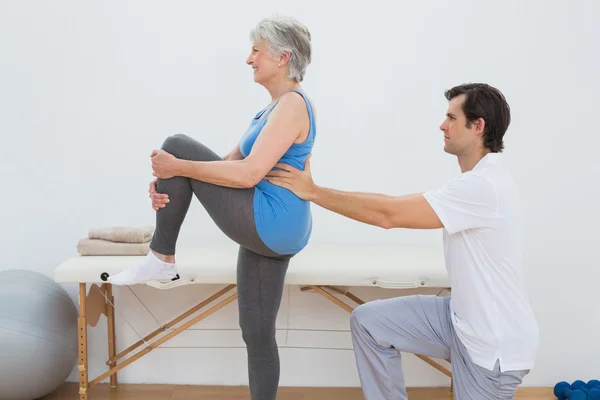 Mannelijke fysiotherapeut senior vrouw terug te onderzoeken — Stockfoto