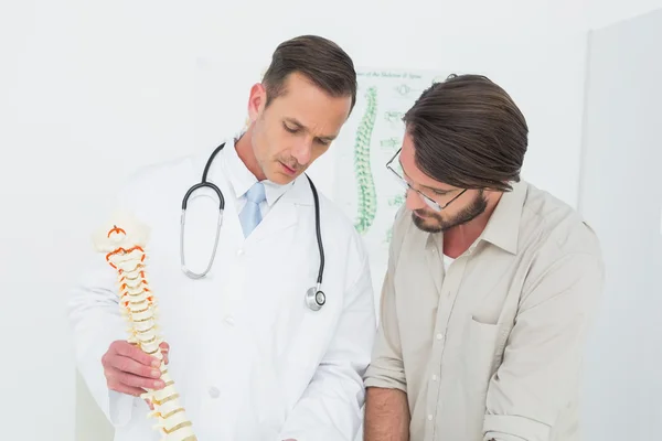 Mężczyzna lekarz tłumacząc kręgosłupa pacjenta — Zdjęcie stockowe