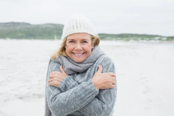 Glückliche Seniorin fühlt sich am Strand kalt — Stockfoto