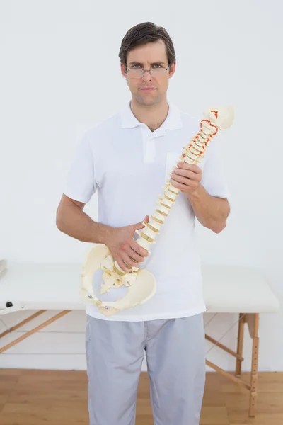 Retrato de um médico confiante segurando modelo de esqueleto — Fotografia de Stock