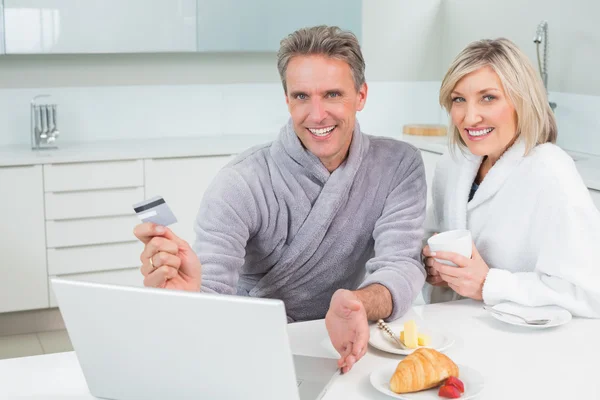 Casal fazendo compras on-line na cozinha — Fotografia de Stock