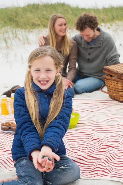 Счастливая семья из трех человек на пляжном пикнике — стоковое фото