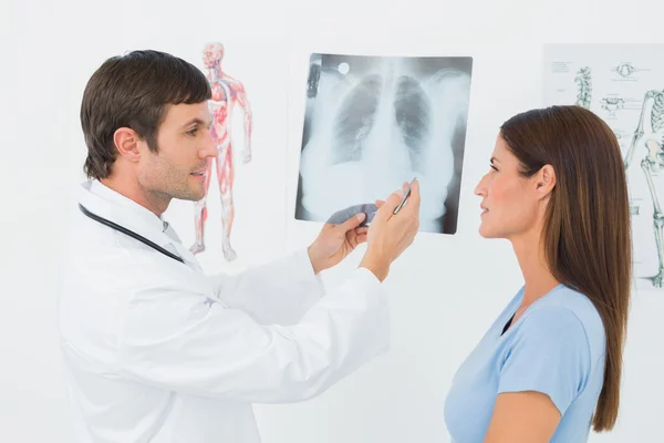 Mężczyzna lekarz tłumacząc RTG płuc do pacjentki — Zdjęcie stockowe