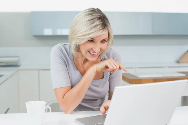 Mulher casual com café usando laptop na cozinha — Fotografia de Stock