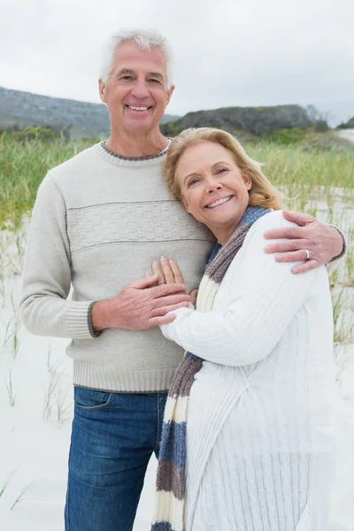Felice uomo anziano abbracciando donna in spiaggia — Foto Stock