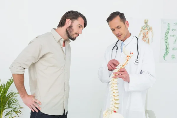 Mężczyzna lekarz tłumacząc kręgosłupa pacjenta — Zdjęcie stockowe