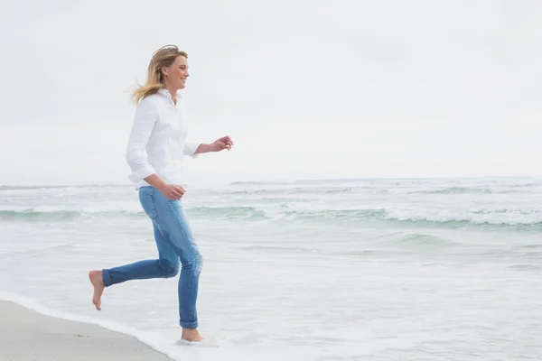 Vista lateral de una mujer corriendo en la playa — Foto de Stock