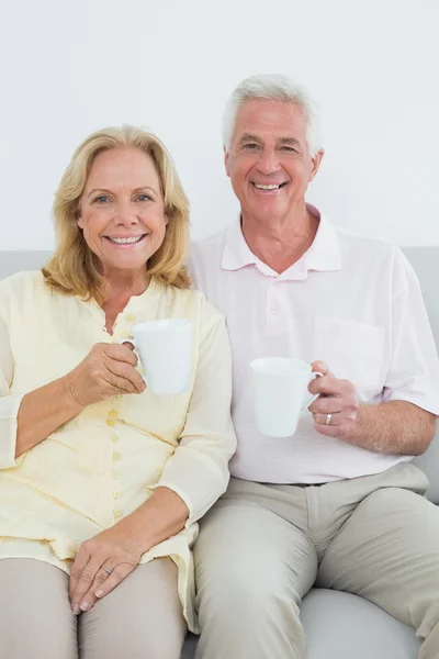 Senior koppel met koffie cups thuis — Stockfoto