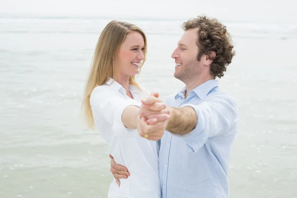 Feliz pareja joven bailando en la playa — Foto de Stock