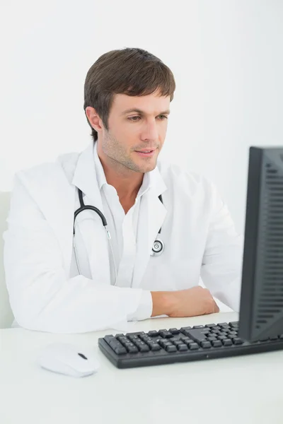 Médico masculino usando computador em consultório médico — Fotografia de Stock