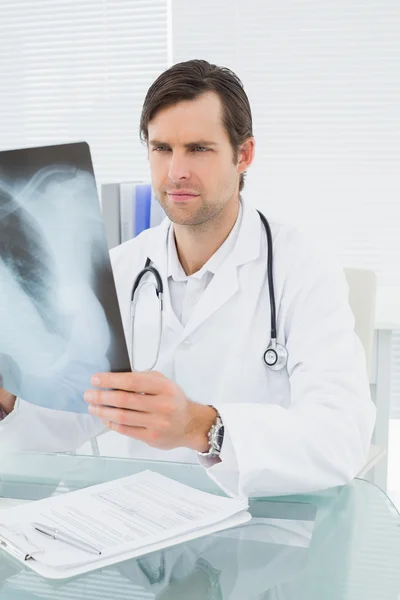 Doctor looking at x-ray picture of lungs in medical office — Stock Photo, Image