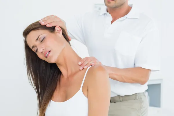 Male chiropractor doing neck adjustment Stock Picture