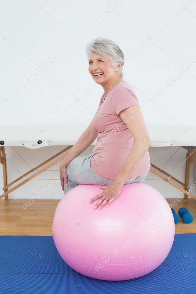Rear view portrait of a senior woman sitting on yoga ball
