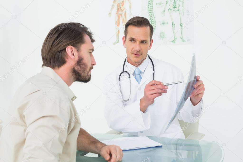 Male doctor explaining spine x-ray to patient