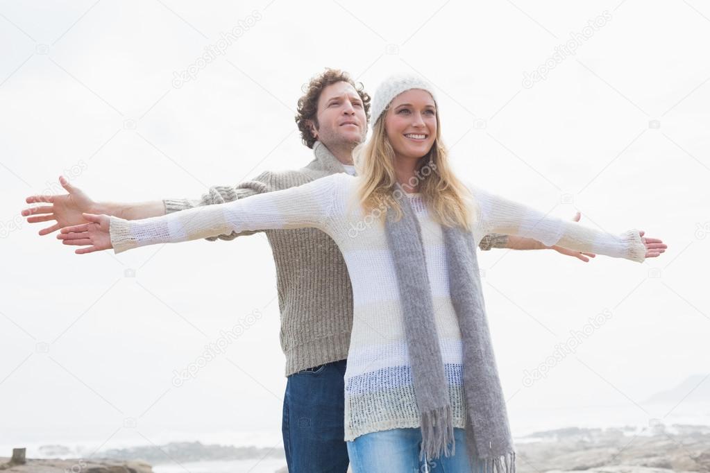 Happy casual young couple stretching hands out