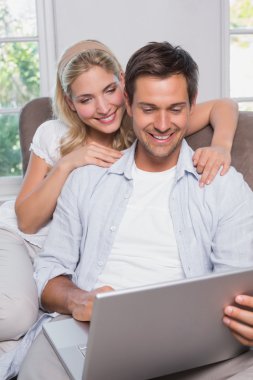 mutlu rahat çift salonda dizüstü kullanarak