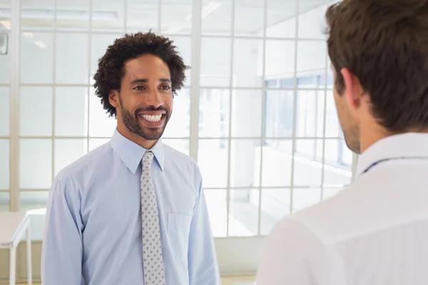 Businessmen looking at each other in office — Stock Photo, Image