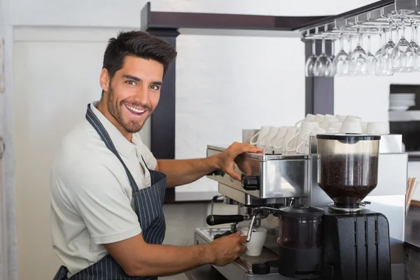 Garçom sorrindo fazendo xícara de café no café — Fotografia de Stock