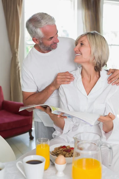 Couple reading newspaper while having breakfast — Stock Photo, Image