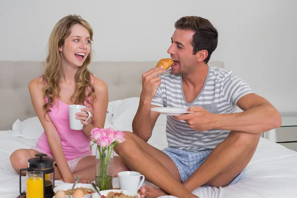 Casal feliz tomando café da manhã na cama — Fotografia de Stock