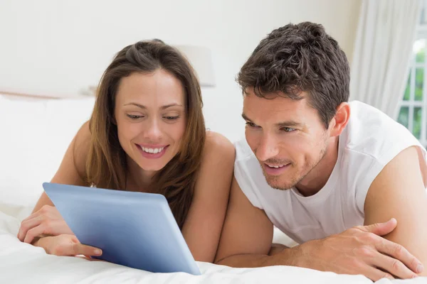 Pareja usando tableta digital en la cama —  Fotos de Stock