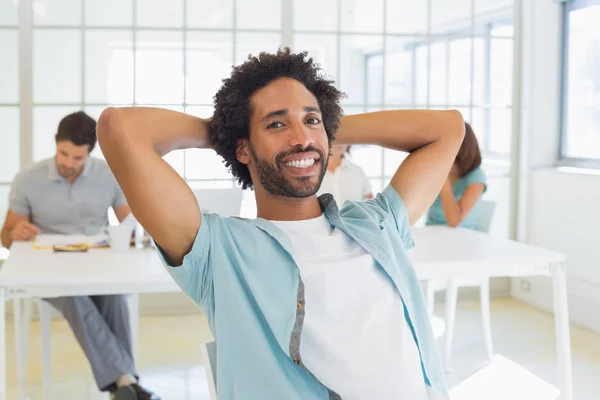 Retrato de un hombre de negocios sonriente con colegas en la reunión — Foto de Stock