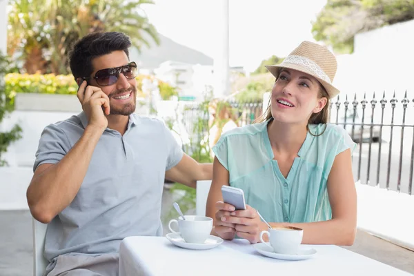 Cep telefonlarıyla kahve dükkanında couple — Stok fotoğraf