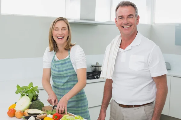 Happy couple preparing food together in kitchen — Stock Photo, Image