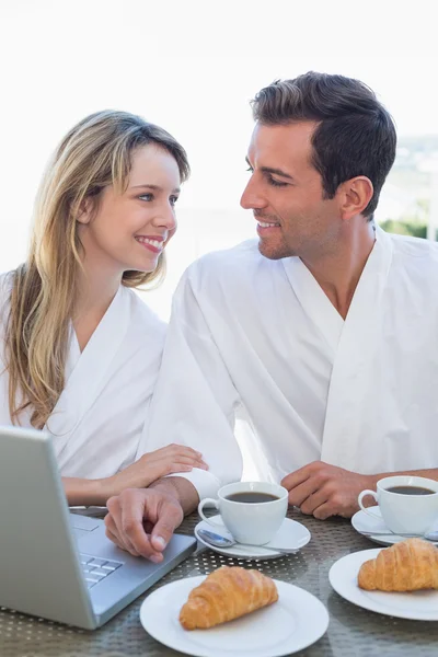 Paar benutzt Laptop auf Frühstückstisch — Stockfoto