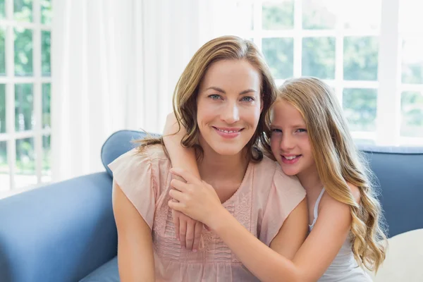 Feliz hija abrazando a madre en la sala de estar —  Fotos de Stock