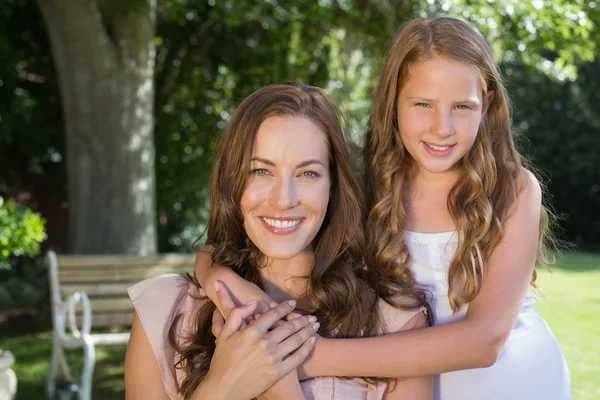 Girl embracing her mother from behind at park — Stock Photo, Image