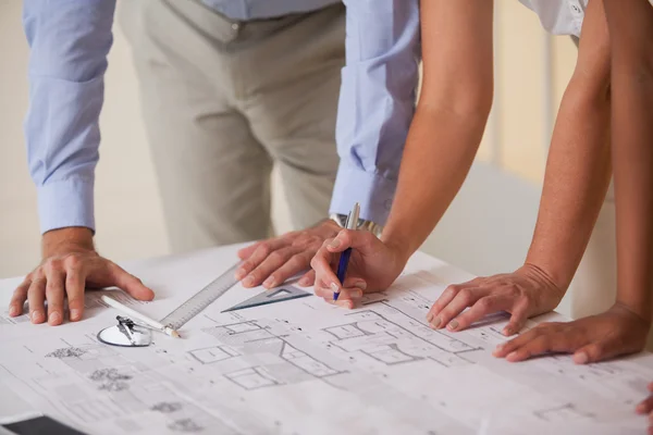 Mid section of business people working on blueprints — Stock Photo, Image