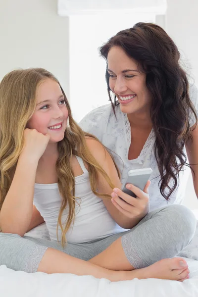 Moeder en dochter met mobiele telefoon — Stockfoto