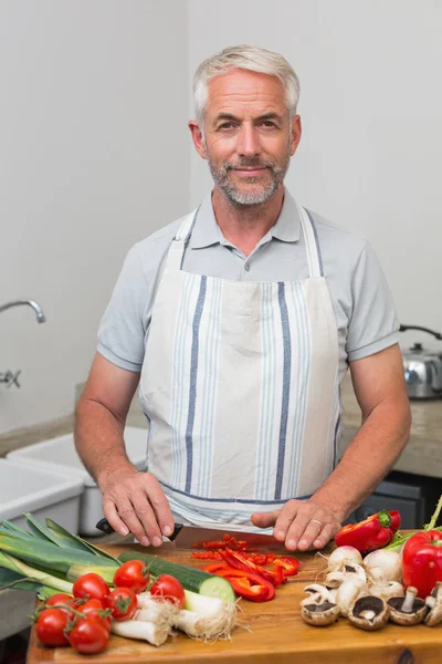 Retrato de un hombre maduro cortando verduras en la cocina —  Fotos de Stock