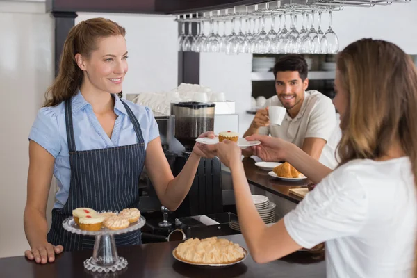 Dono do café dando comida doce para um casal no café — Fotografia de Stock