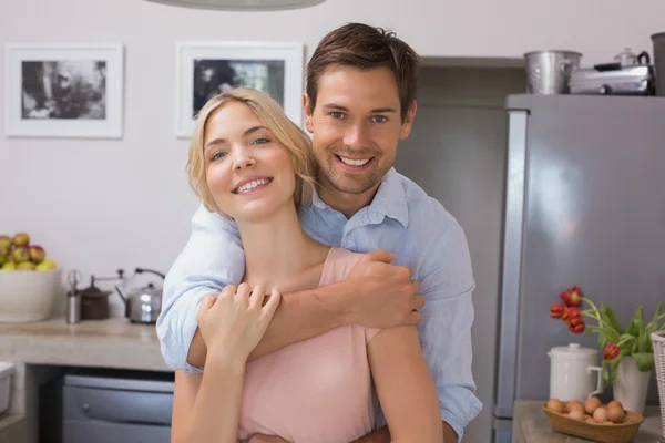 Hombre abrazando a la mujer por detrás en la cocina — Foto de Stock