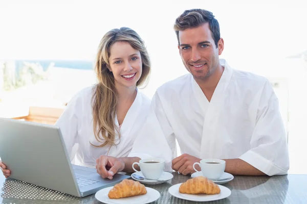 Pareja usando portátil en mesa de desayuno —  Fotos de Stock