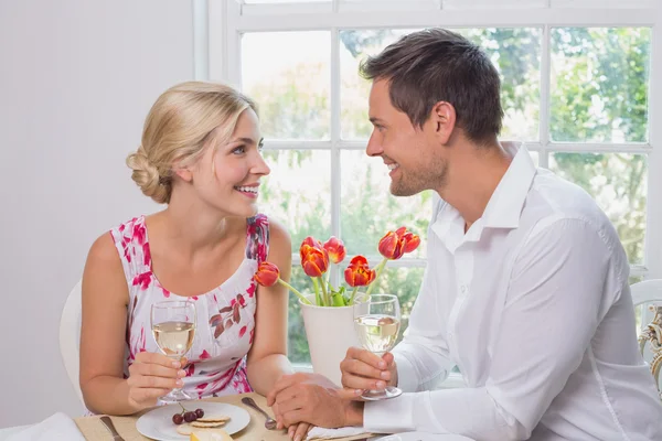 Felice giovane coppia con bicchieri di vino avendo cibo — Foto Stock