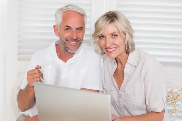 Lachende ouder paar laptop thuis gebruiken — Stockfoto
