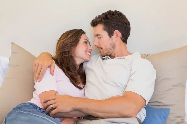 Loving couple sitting on couch at home — Stock Photo, Image