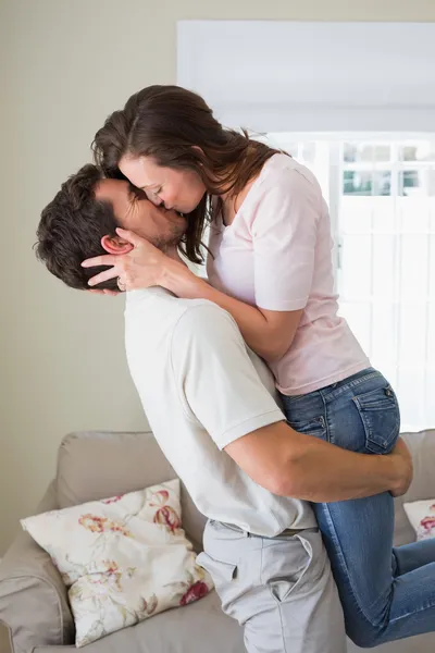 Amar pareja joven besándose en la sala de estar —  Fotos de Stock
