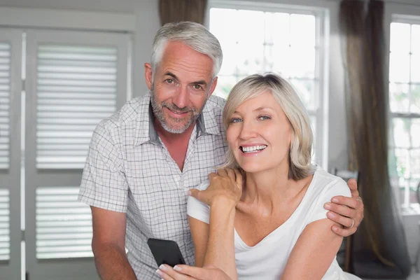 Happy mature couple reading text message at home — Stock Photo, Image